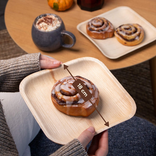 Pumpkin Spice Latte mit Zimtschnecken auf Palmblatttellern