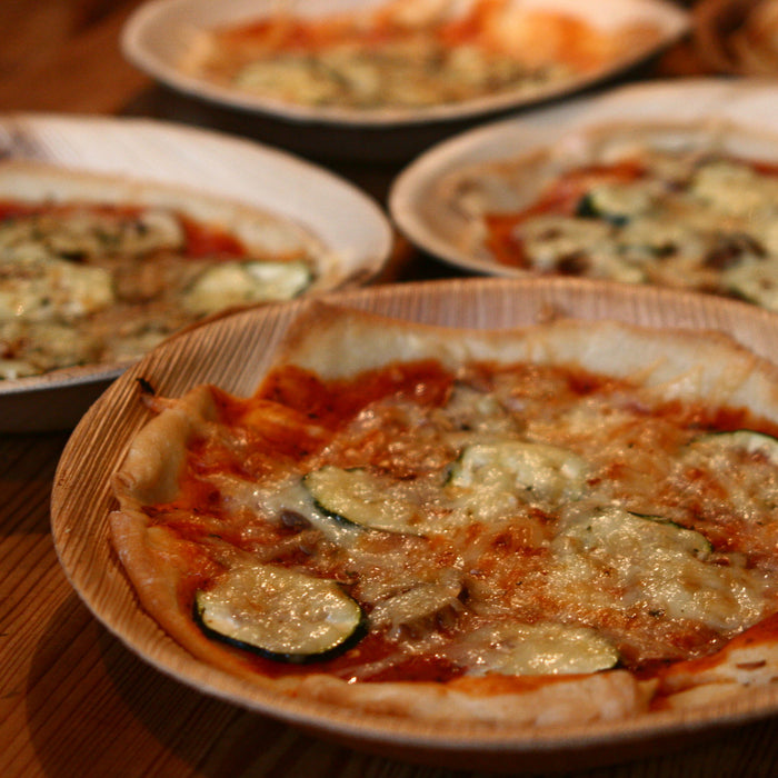 Pizza auf runden Palmblattteller